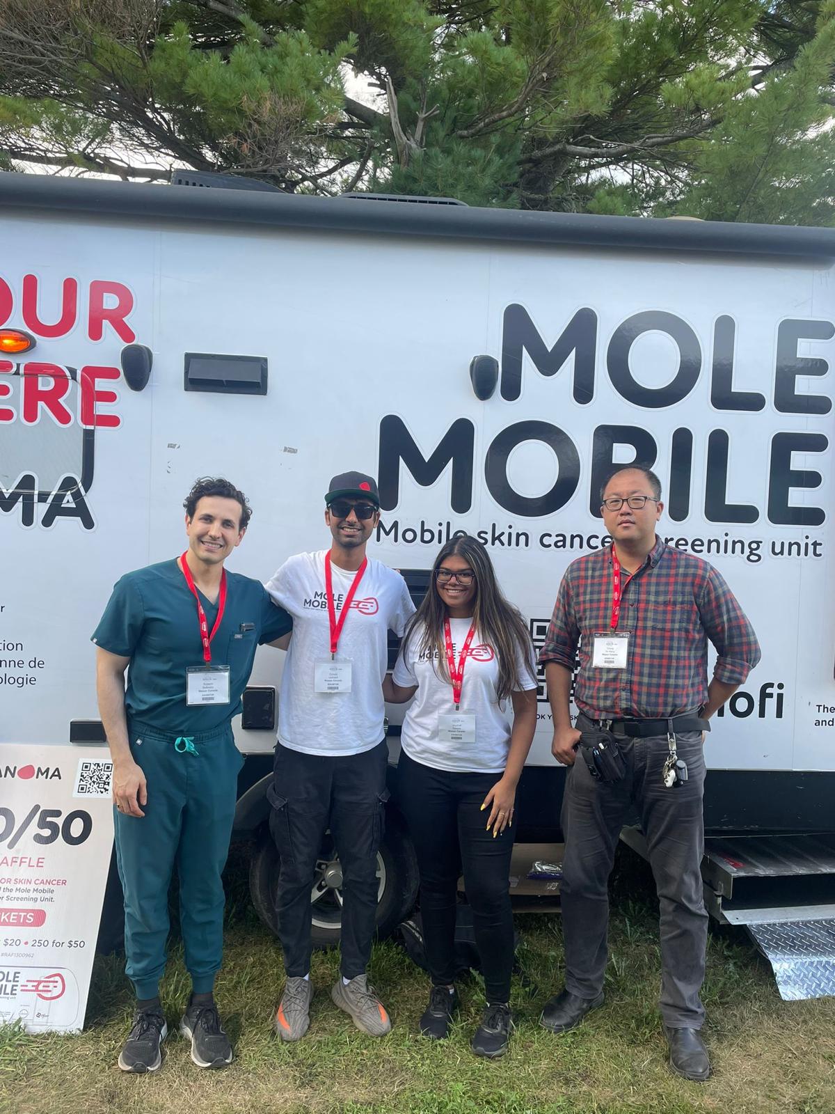 Mole Mobile campaign team members standing together beside the mobile screening unit.